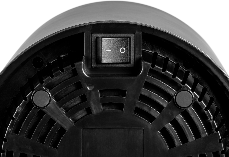 Onderkant van een zwart apparaat met een aan/uit-schakelaar en ventilatiegaten.