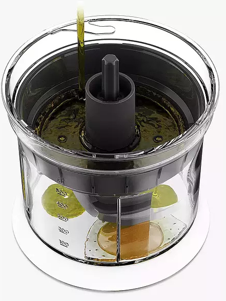 Un robot culinaire transparent avec de l'huile d'olive versée dedans.