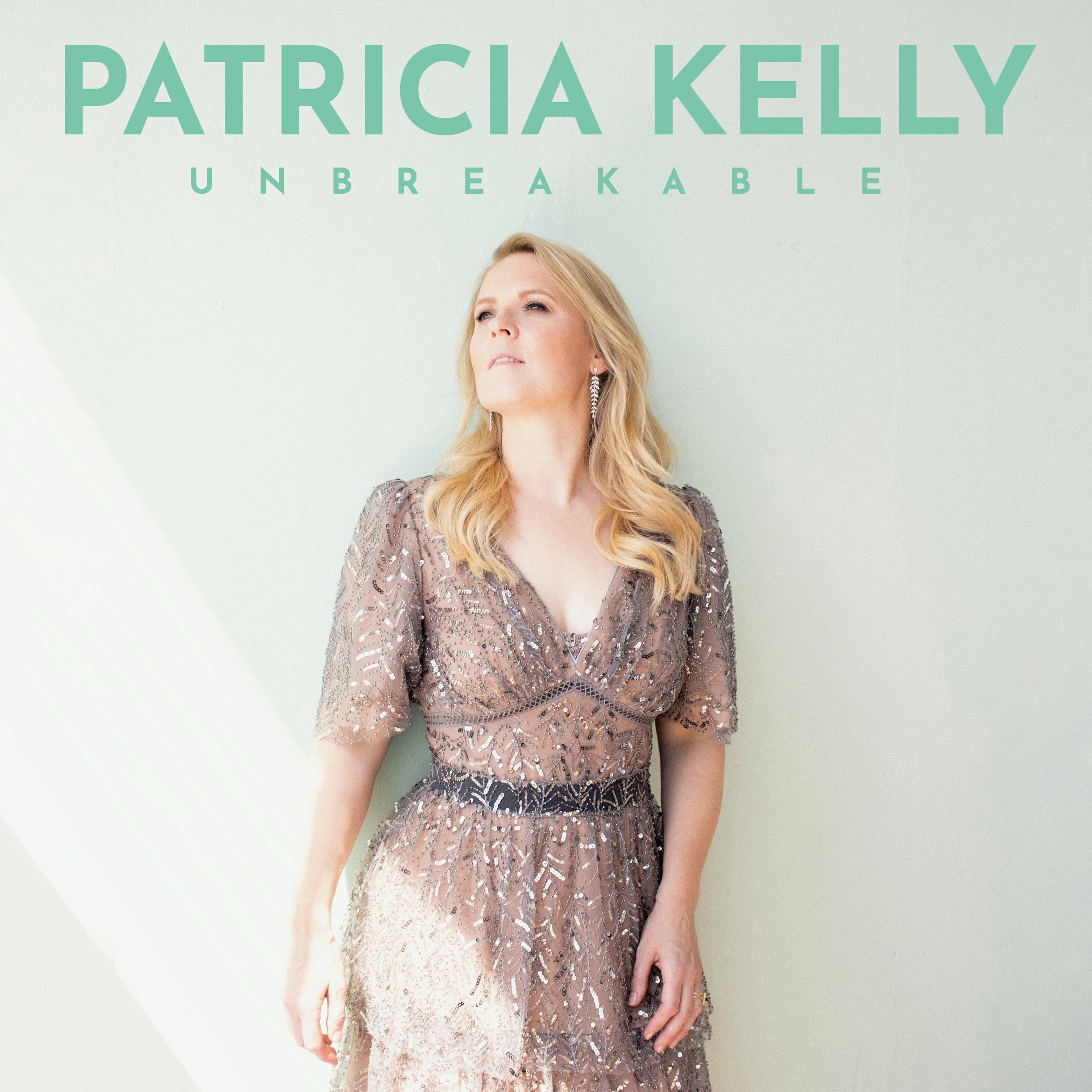 Frau im Kleid, Albumcover, Titel Patricia Kelly Unbreakable, hellgrüner Hintergrund.