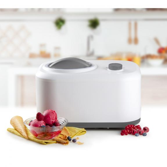 Witte ijsmachine met ijs en bessen, wazige keuken op de achtergrond.