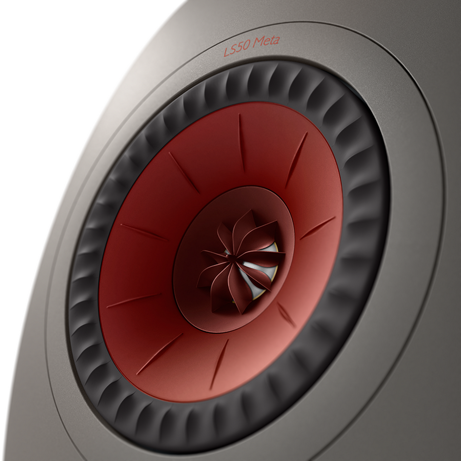 Primer plano de un altavoz. Centro rojo, borde negro, marco gris. Texto 'LS50 Meta'.