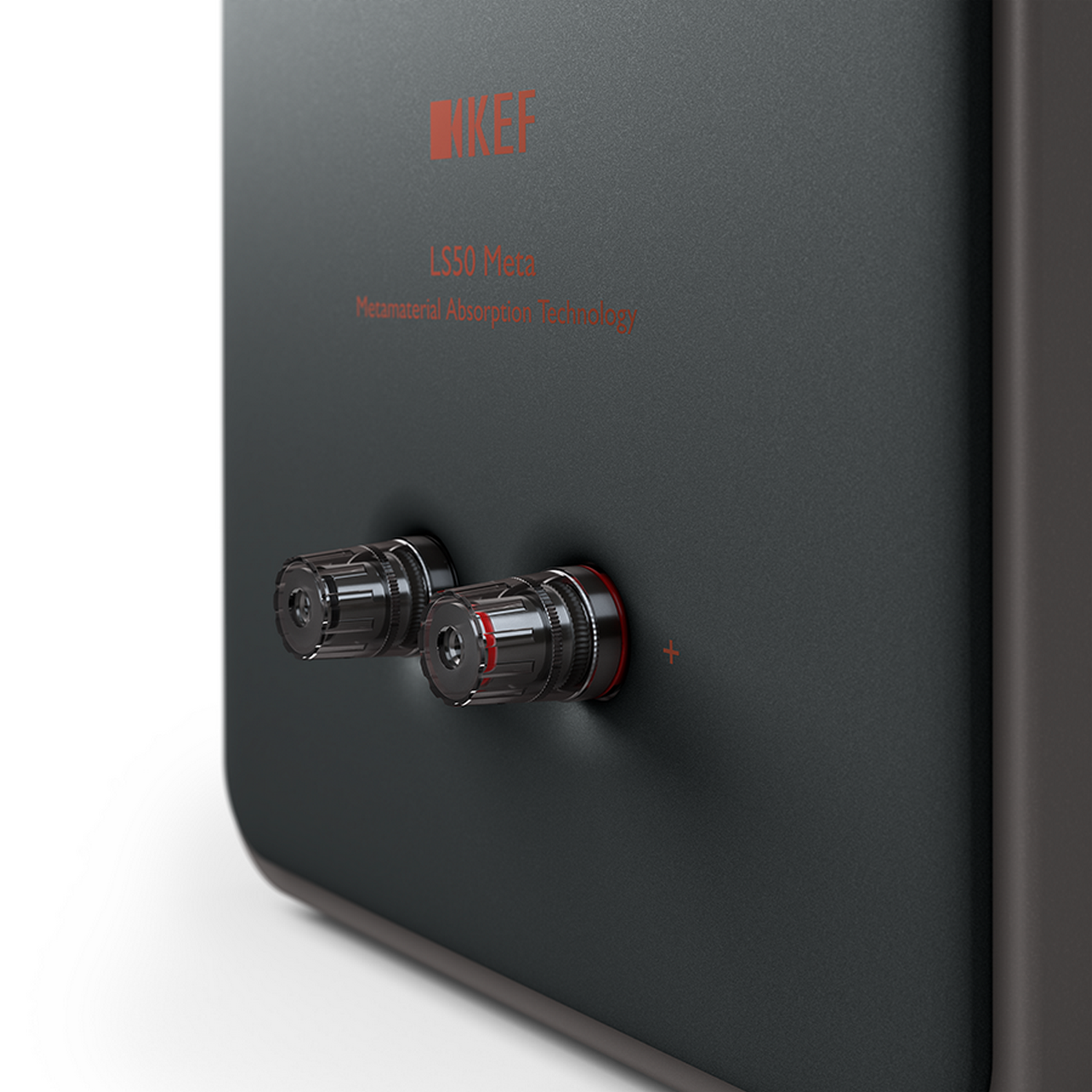 Primer plano de terminales de altavoz negros con detalles rojos. Visible la marca 'KEF'.