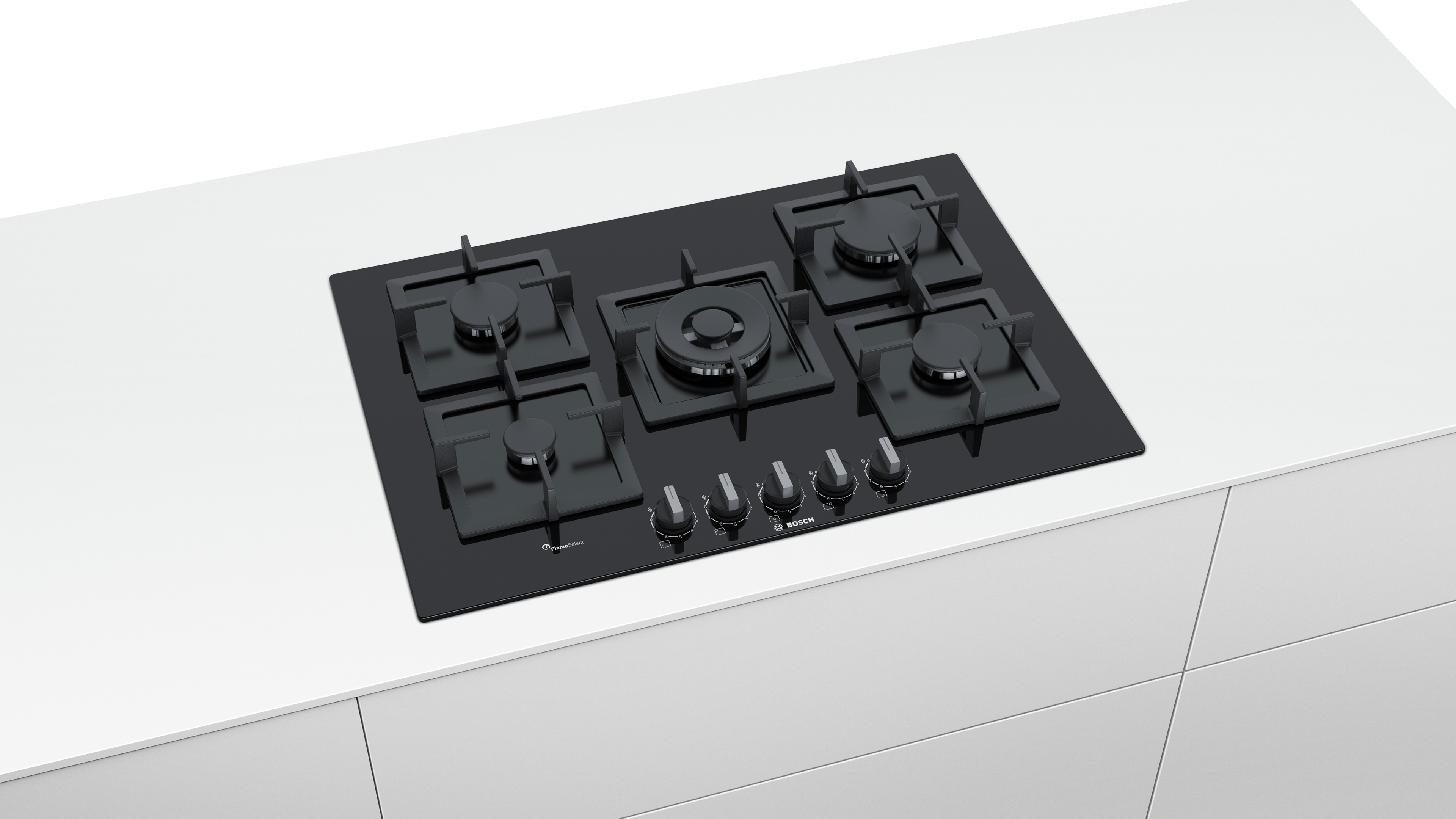 A black gas hob with five burners and control knobs on a white countertop. The hob is flush with the surface.