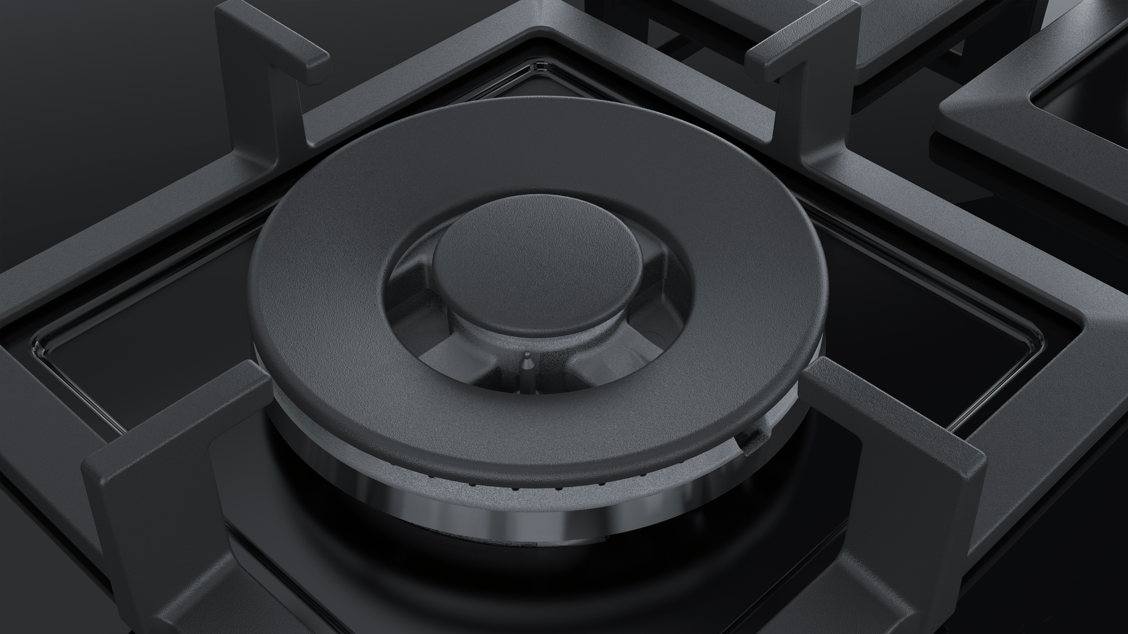 Close-up of a black gas stove burner with a central ring. The burner is on a black surface.