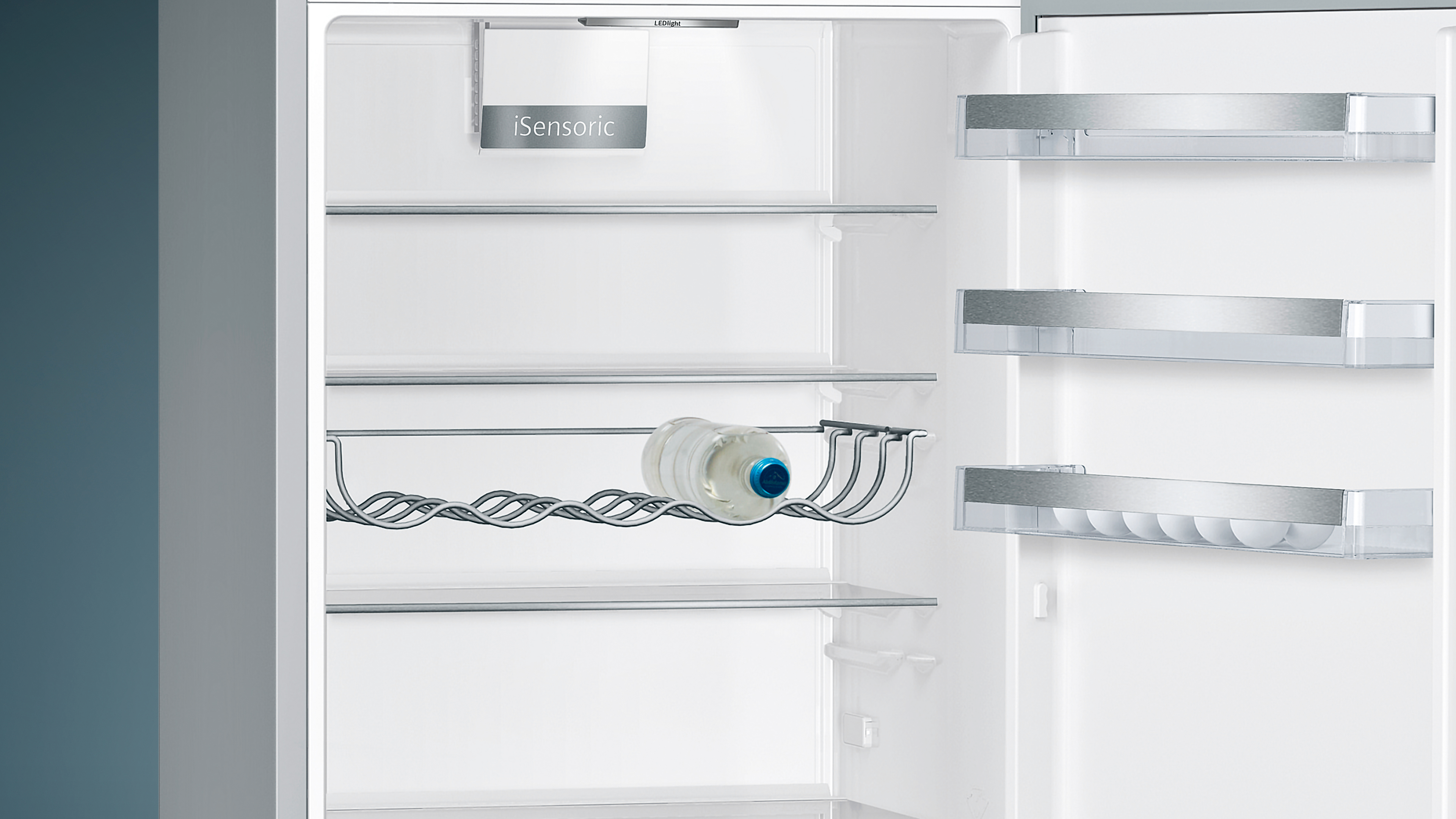 Opened refrigerator with water bottle in wire rack.