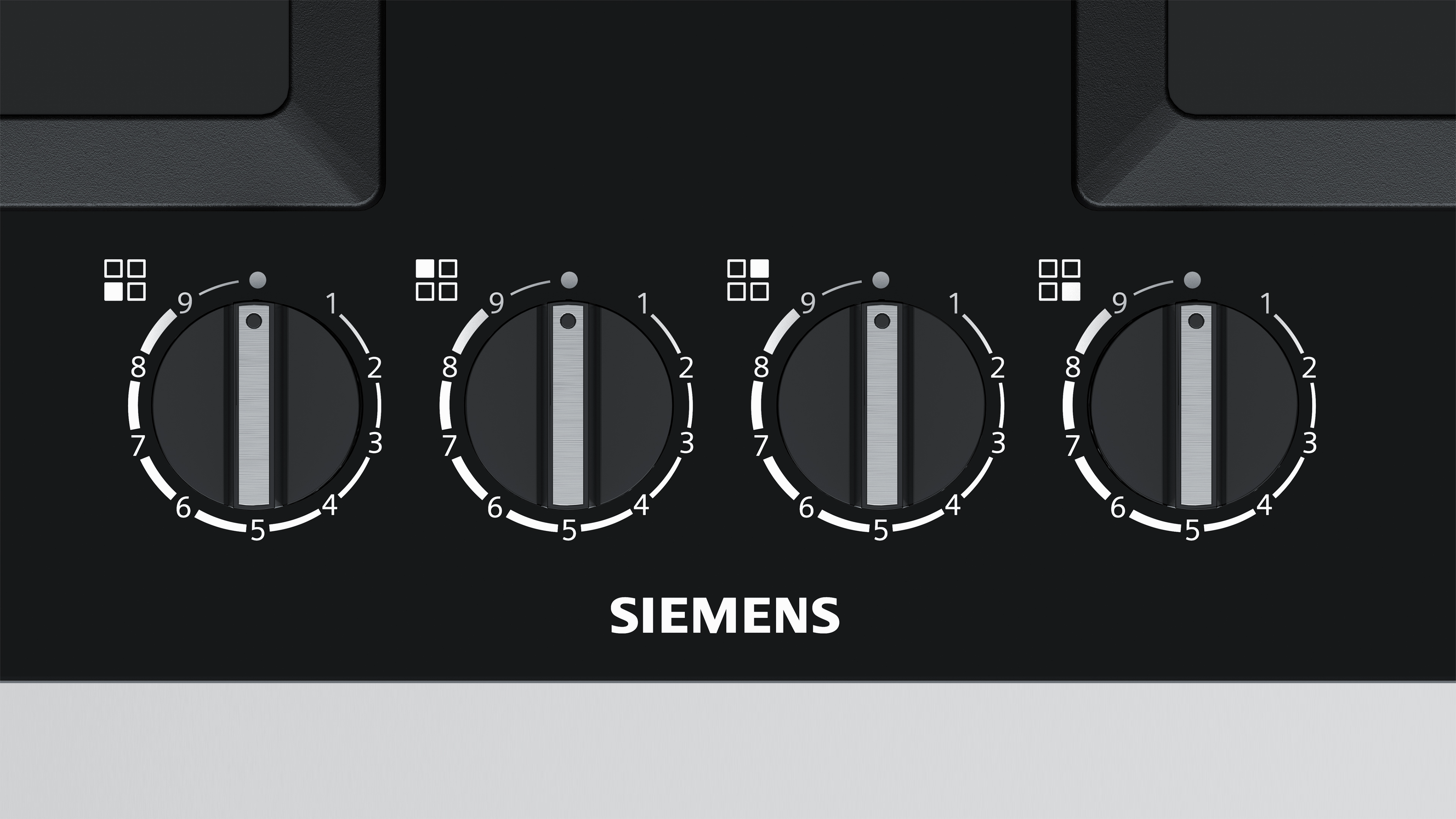 Close-up of four black Siemens stove knobs.