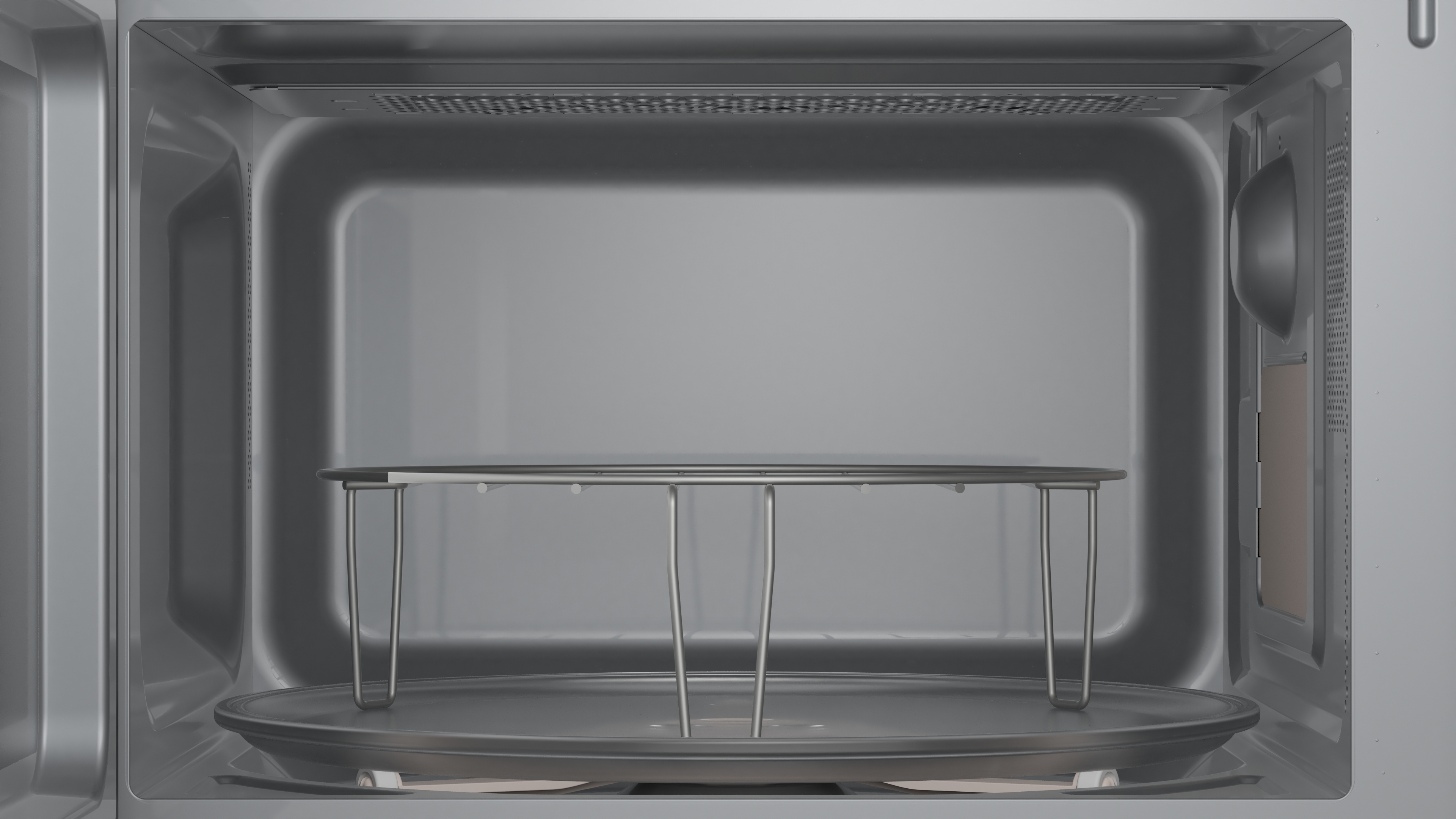 Das Innere einer sauberen Mikrowelle mit einem silbernen Metallgitter auf dem Drehteller.