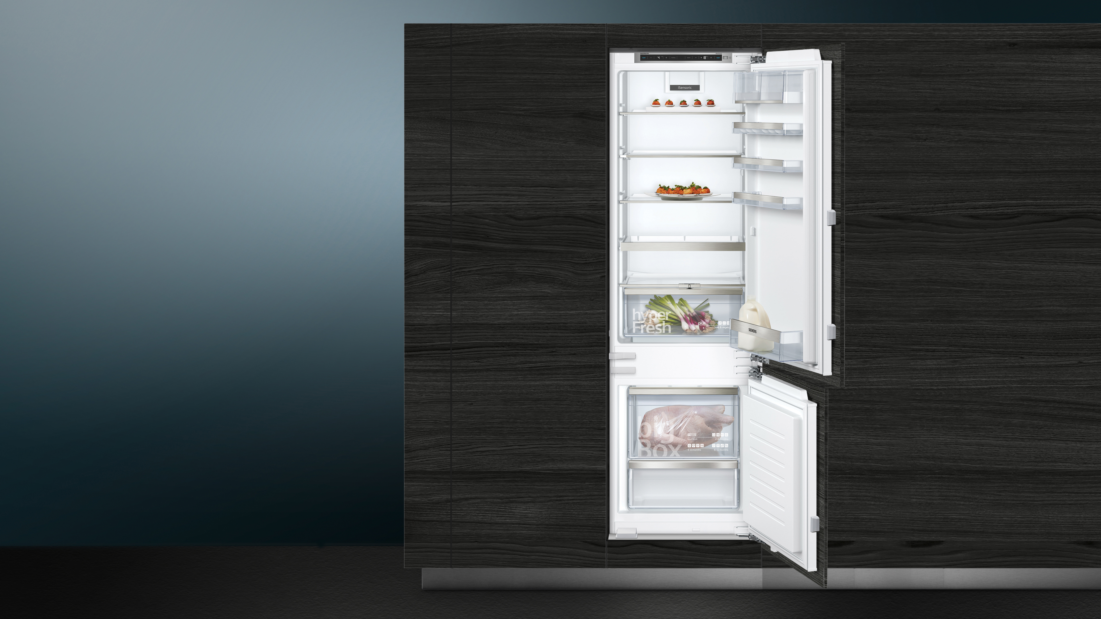 Geöffneter Kühlschrank mit Regalen, Lebensmitteln und einer unteren Gefrierschublade.