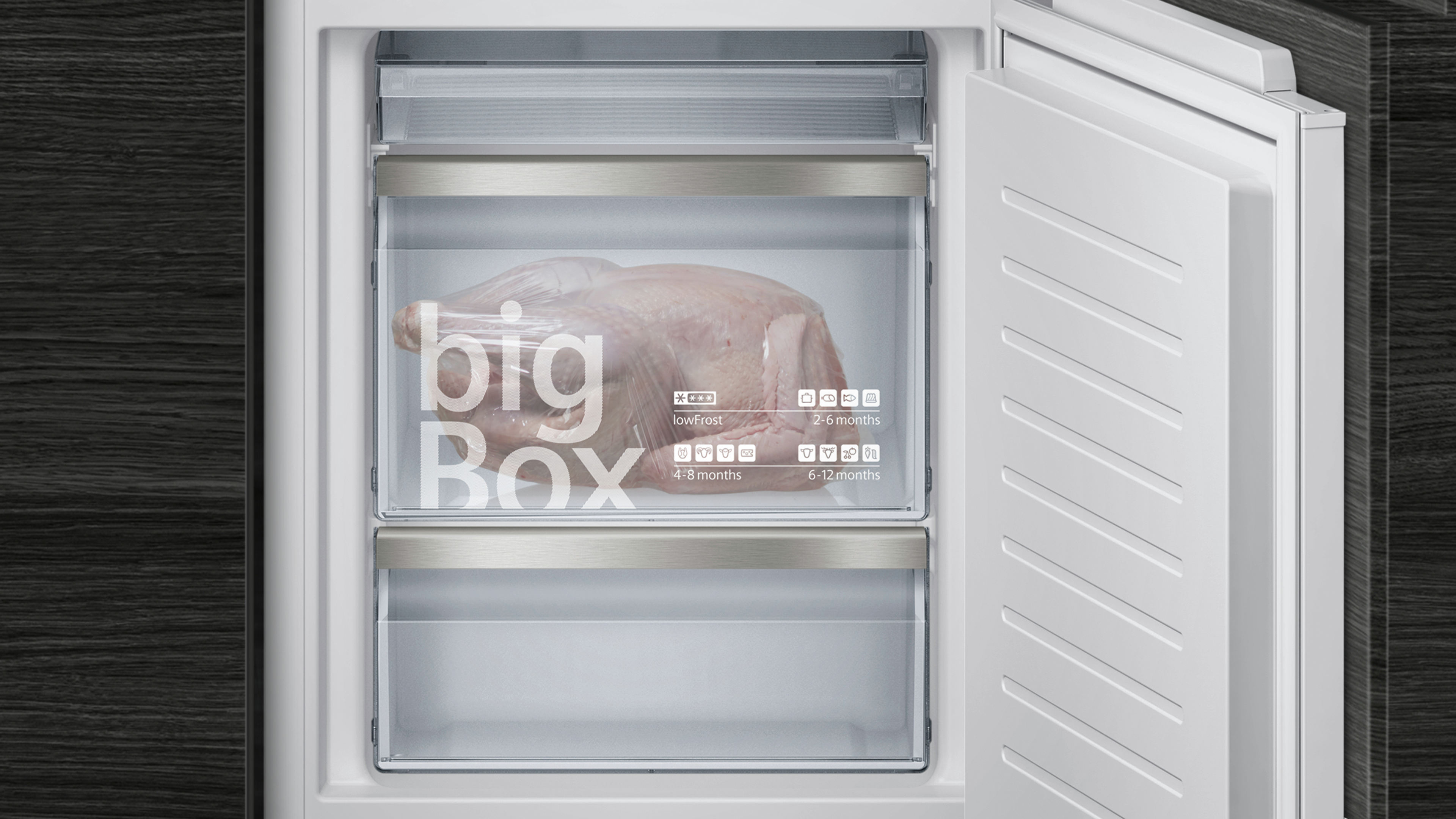 Ein Gefrierschrank mit offener Tür, der ein großes Huhn in der bigBox-Schublade zeigt.