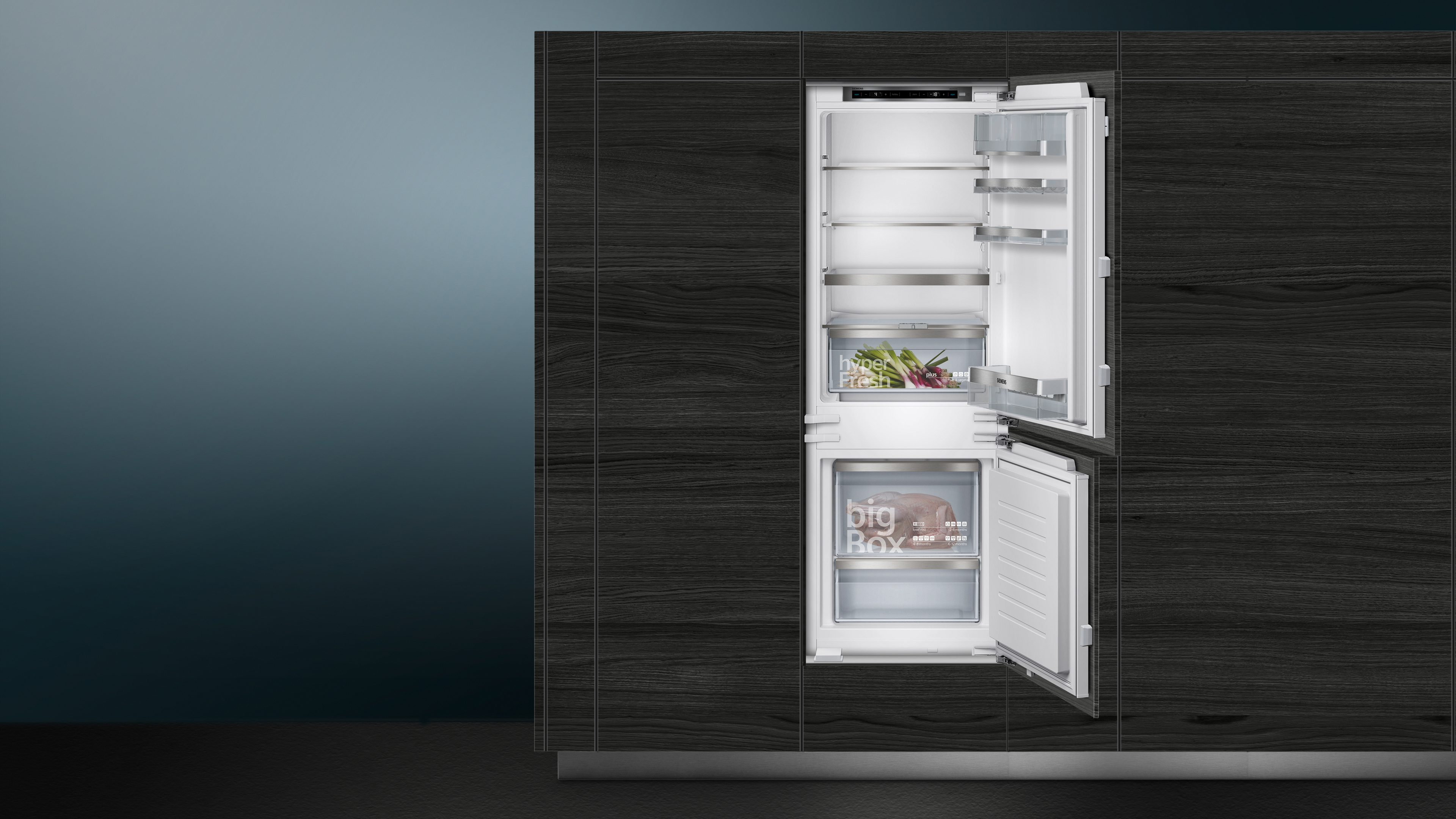 Geöffneter Kühlschrank aus Edelstahl mit Regalen. Die linke Tür ist geschlossen. Holzverkleidung umgibt das Gerät.