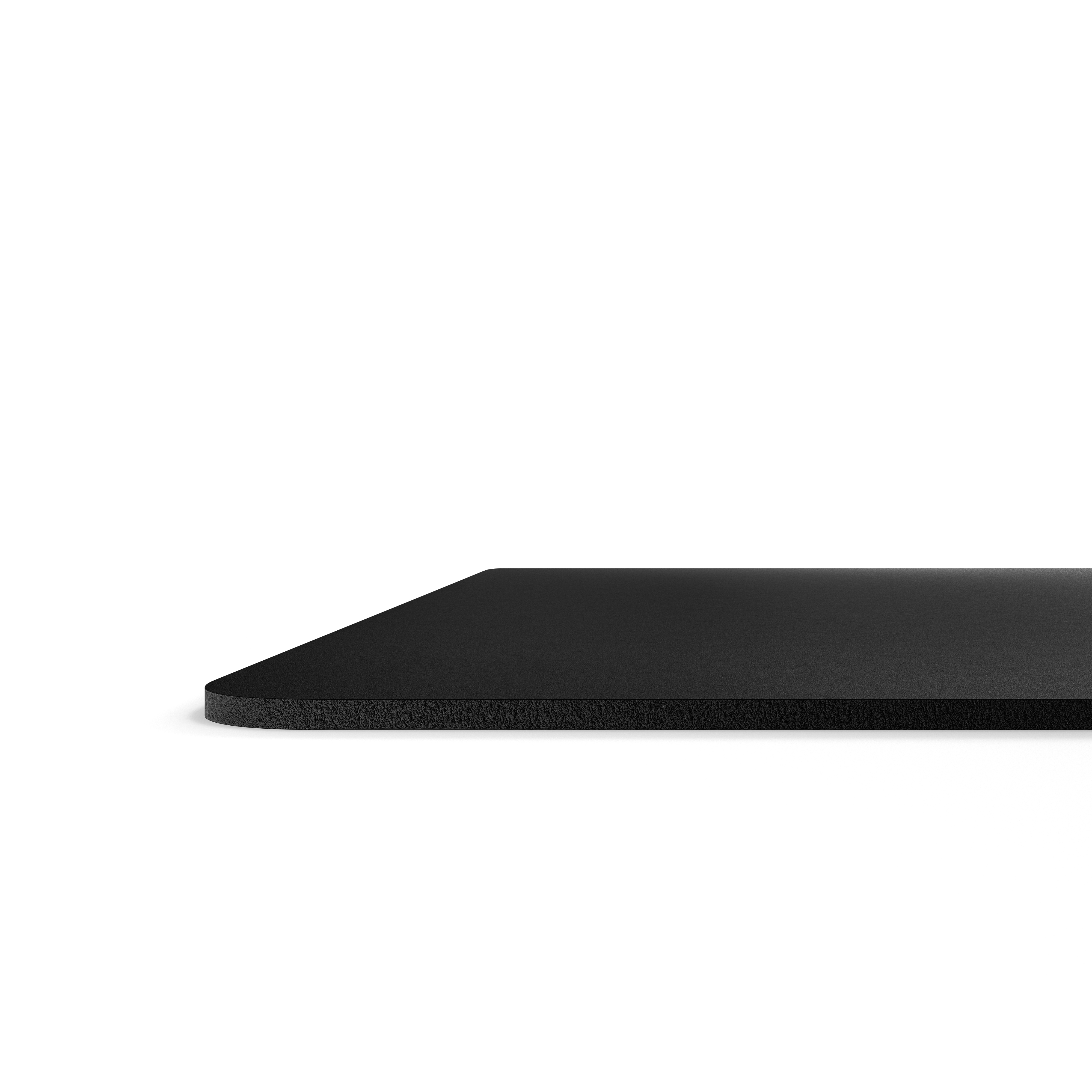 A flat, black surface viewed from the side against a white backdrop.