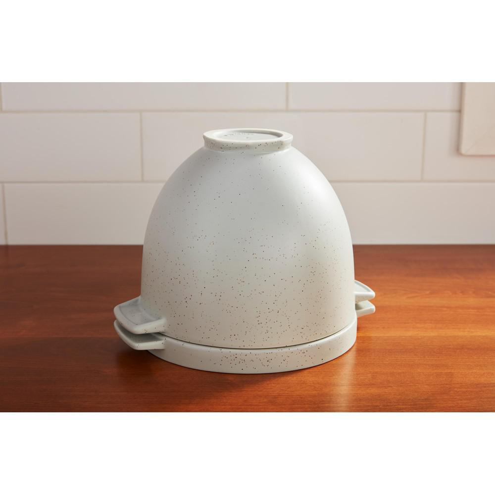 Eine graue, gesprenkelte Keramik-Cloche auf einer Holzoberfläche.