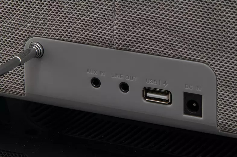 Panneau arrière d'un haut-parleur gris avec ports AUX IN, LINE OUT, USB et DC IN.