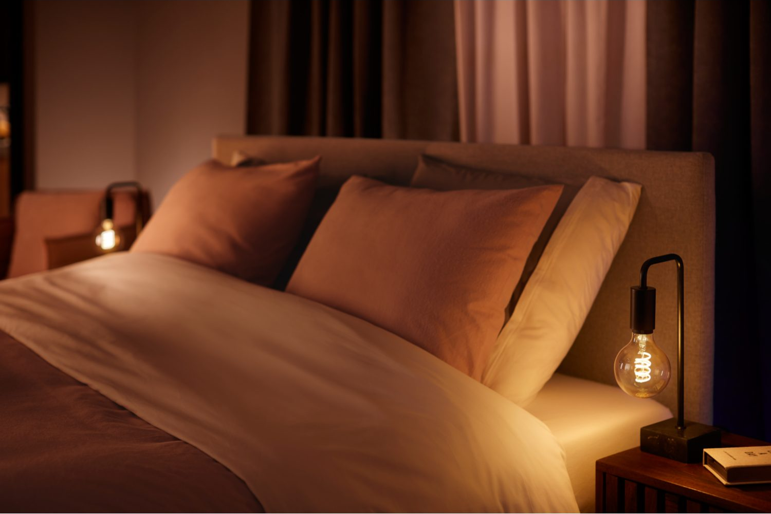 Scène de chambre la nuit. Lit avec oreillers, table de chevet avec lampe.