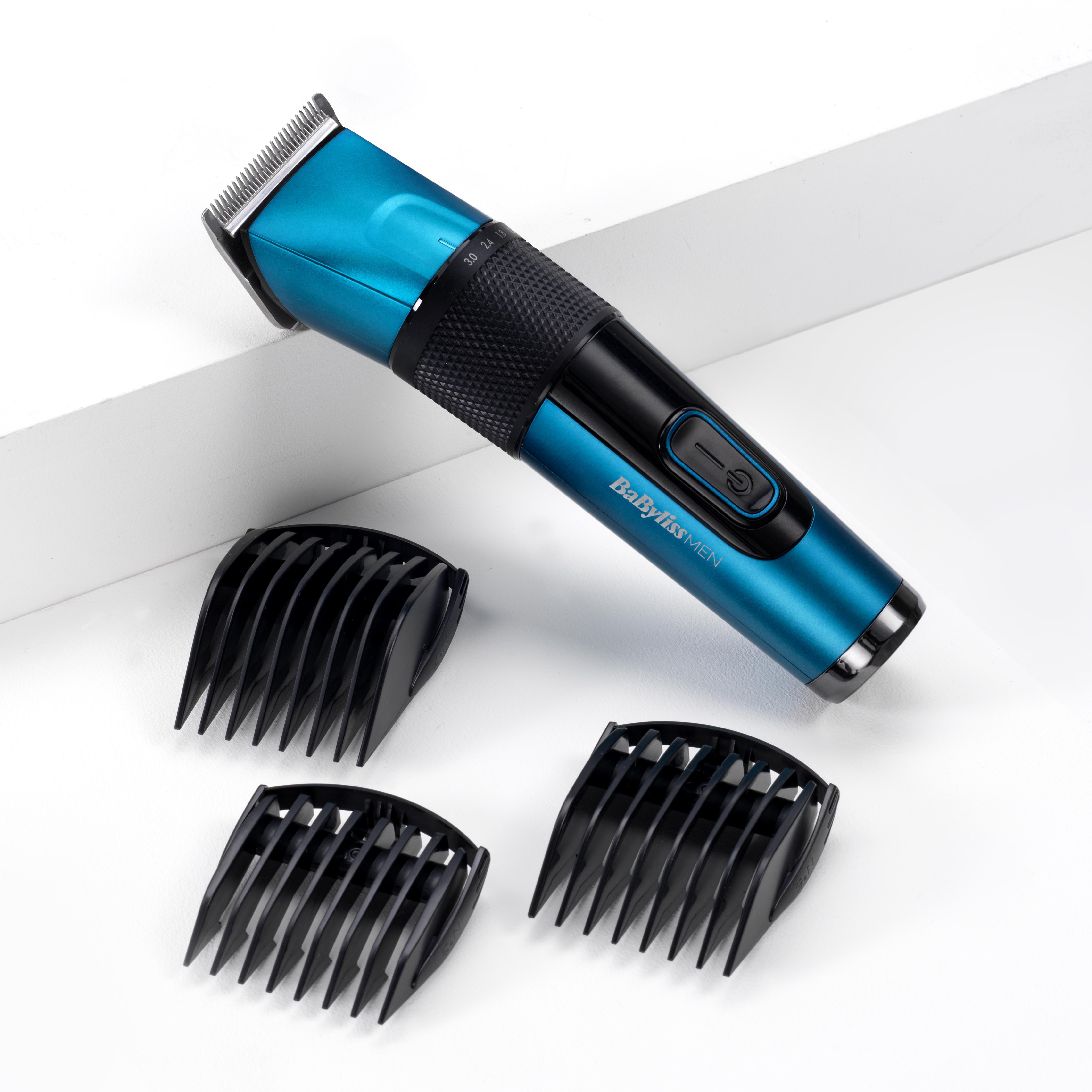 Ein blau-schwarzer Haarschneider mit drei schwarzen Trimmaufsätzen auf weißer Oberfläche.