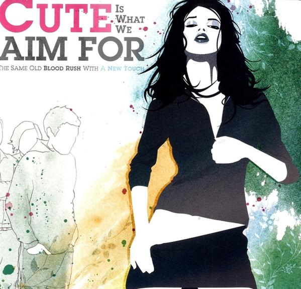 A 'Cute Is What We Aim For' album borítója. Fekete ruhás nő, emberek.