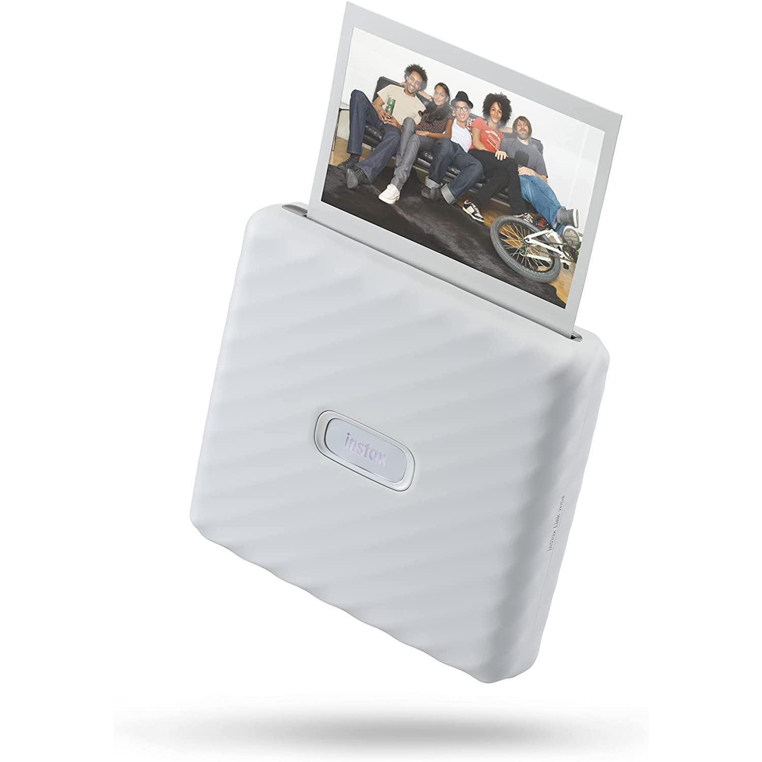 Impresora Instax blanca con una foto de personas en un sofá. La foto sale de la impresora.
