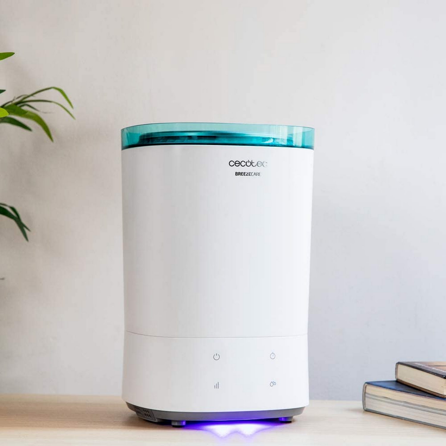 Un humidificador blanco con tapa azul sobre una mesa de madera.
