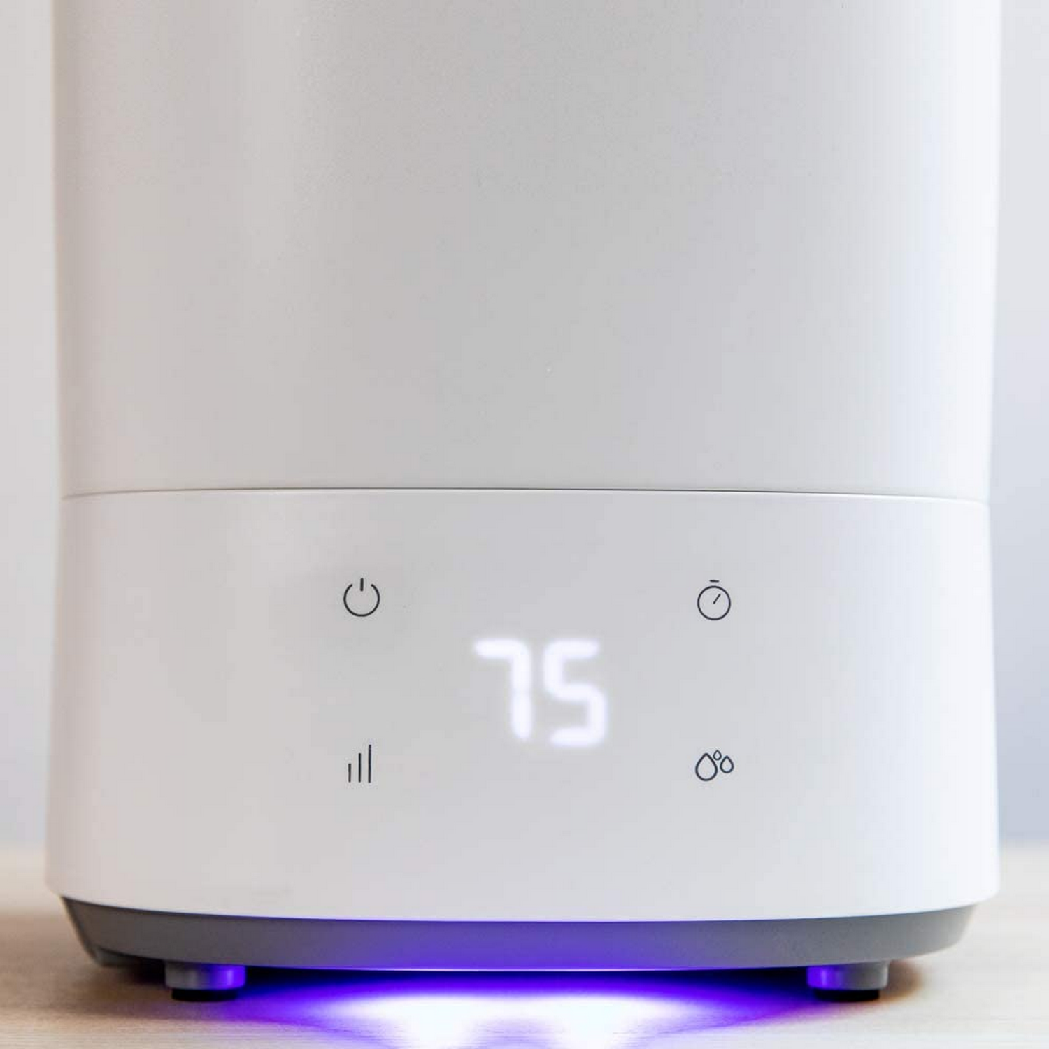 El humidificador blanco muestra 75. Iconos de encendido, temporizador, señal, gota.