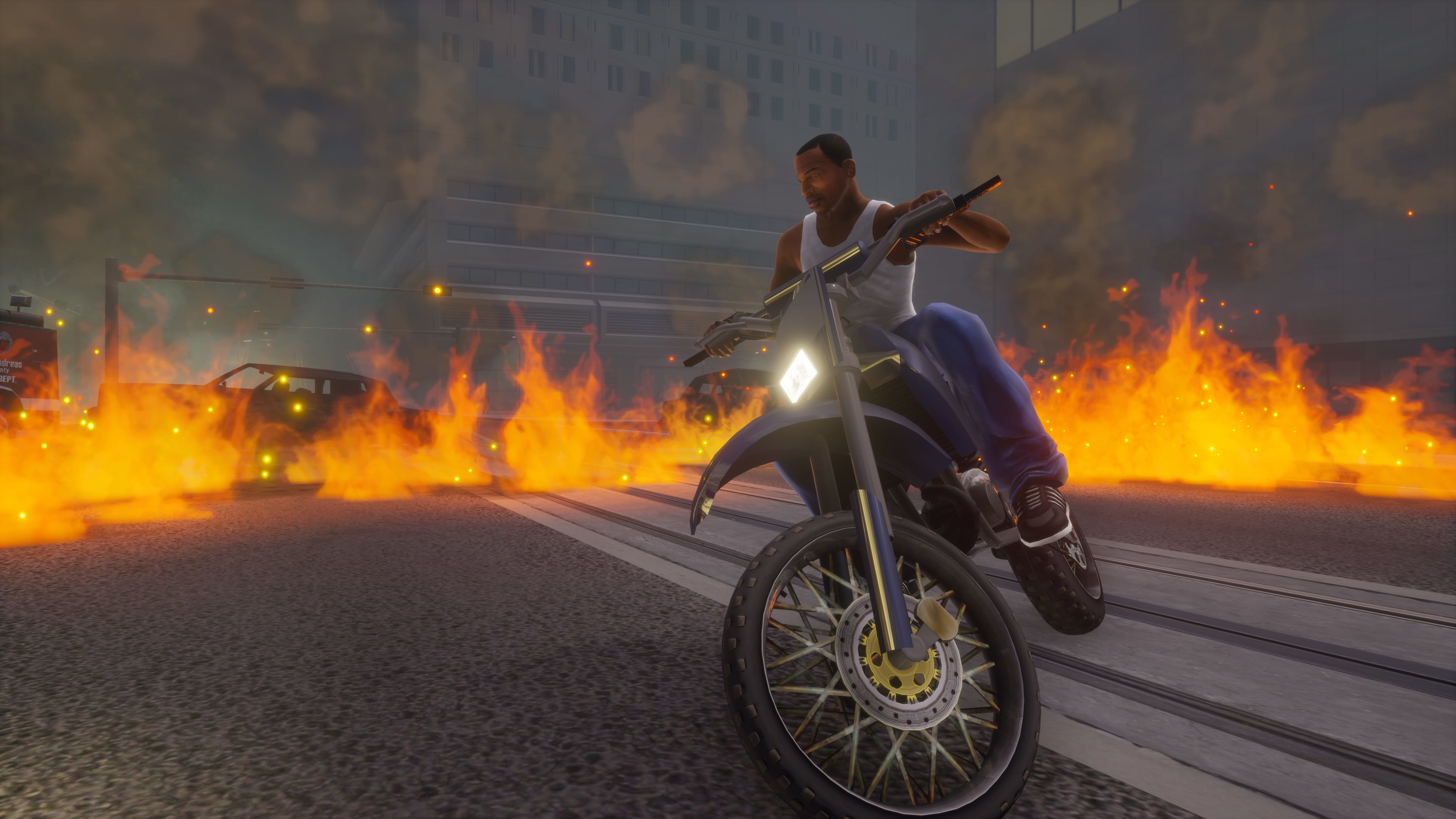 Motocycliste sur une moto bleue, roulant sur une route en proie aux flammes et à la fumée.
