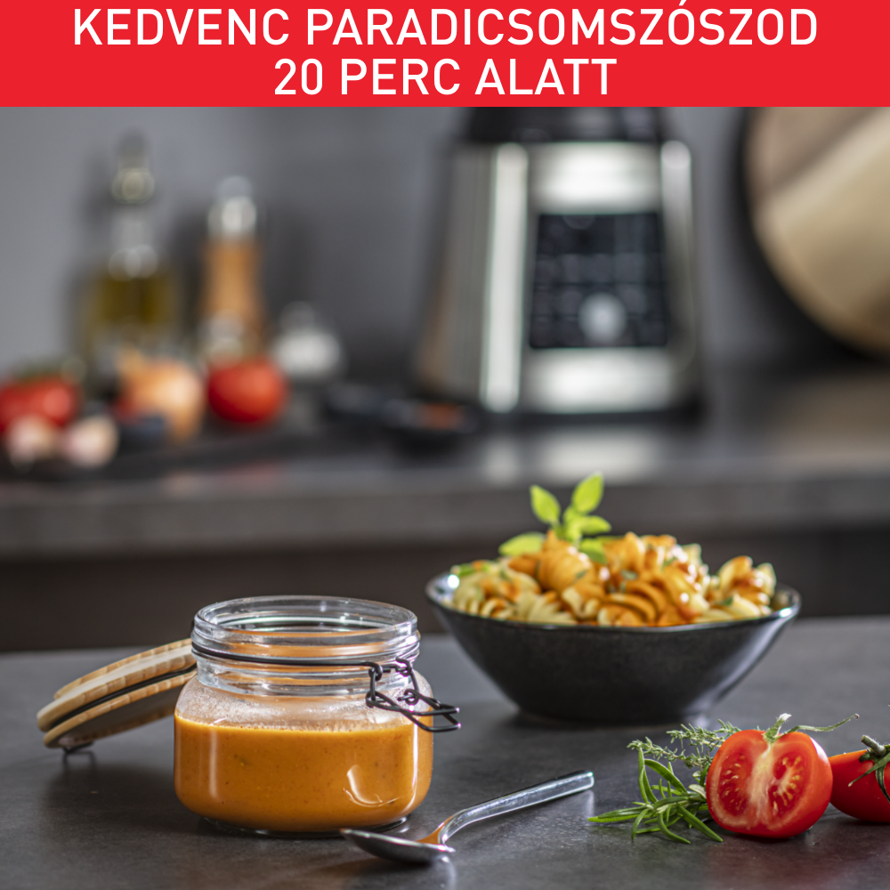 Paradicsomleves üveg tésztával, paradicsommal és egy turmixgéppel a háttérben.