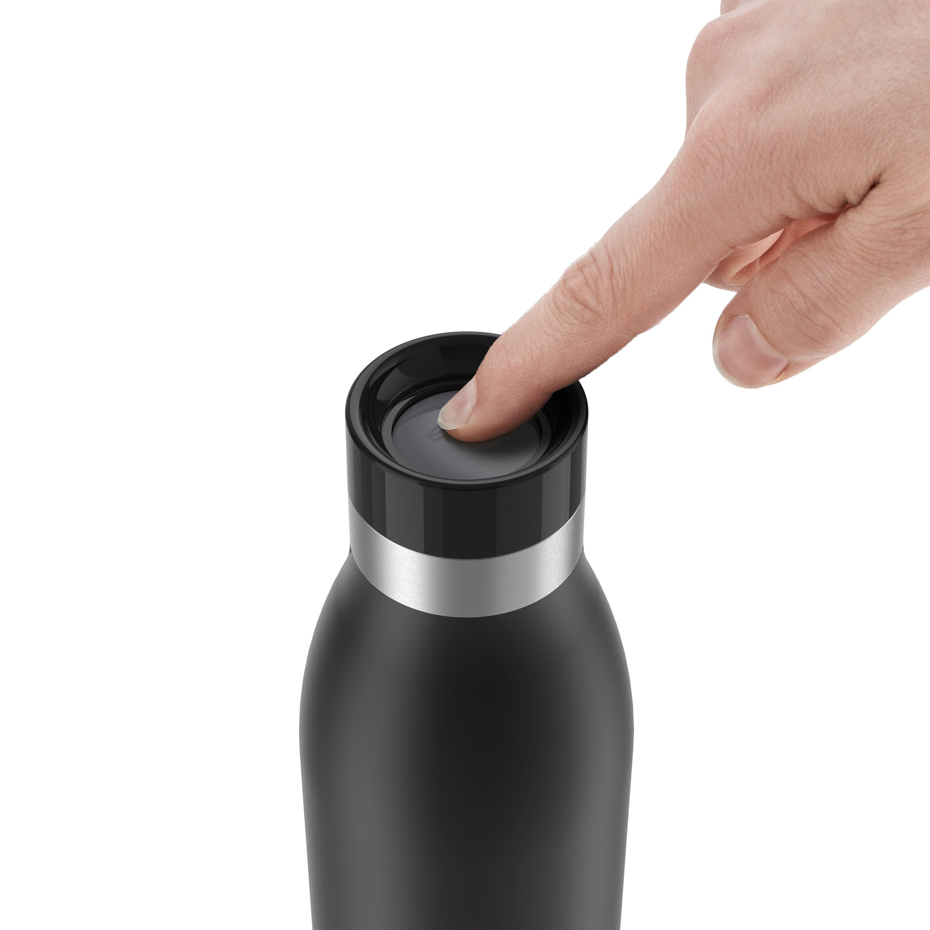 Ein Finger drückt auf den Knopf einer schwarzen Wasserflasche mit silbernem Band.
