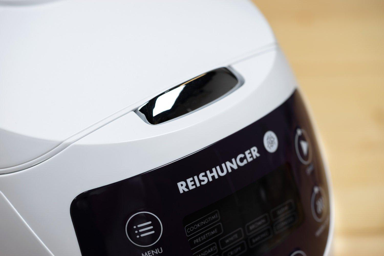 Nahaufnahme eines weißen Reiskochers mit dem Markennamen 'Reishunger'.