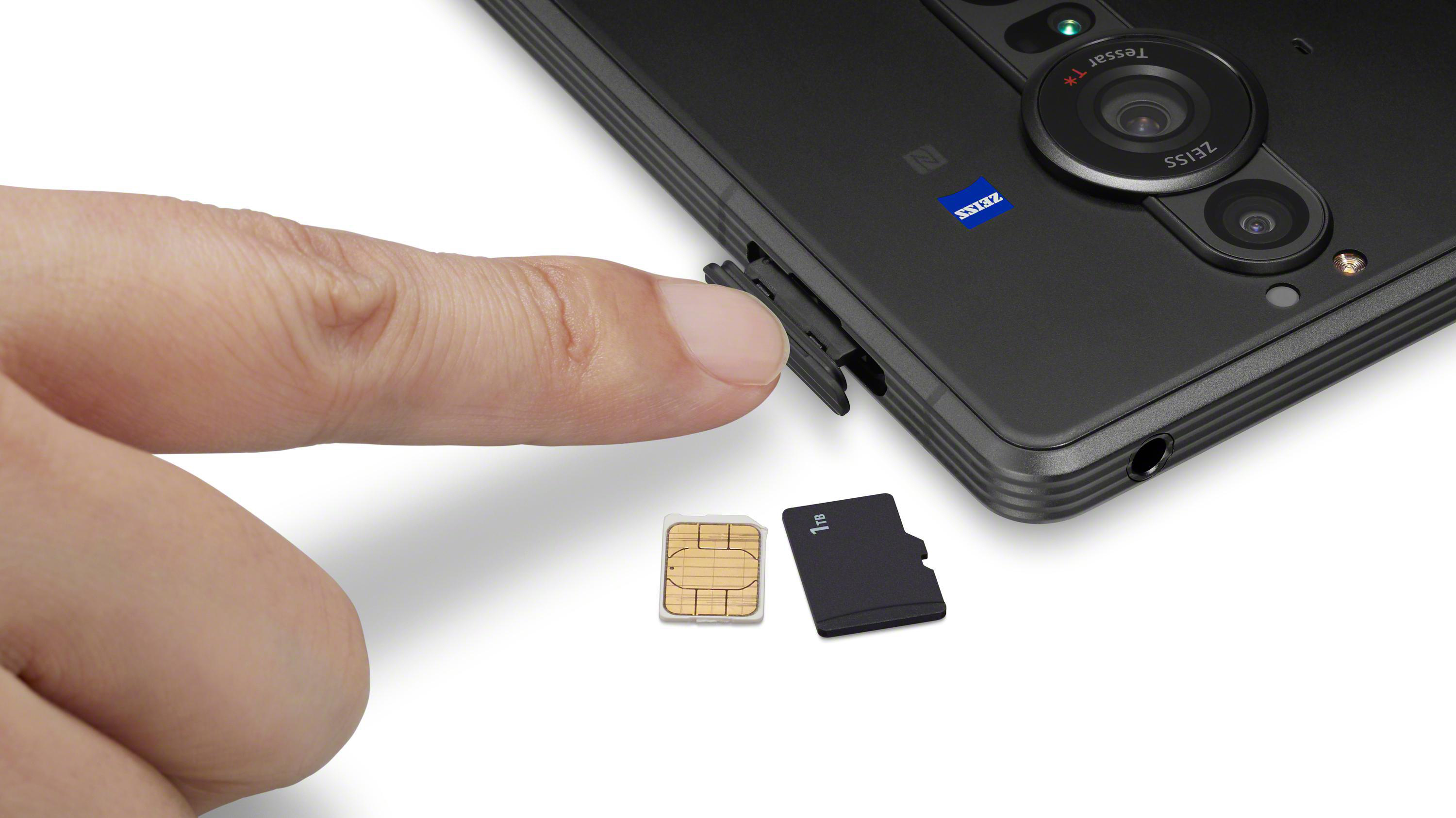 Eine Hand, die eine SIM-Karte und eine Micro-SD-Karte in ein schwarzes Telefon einlegt.