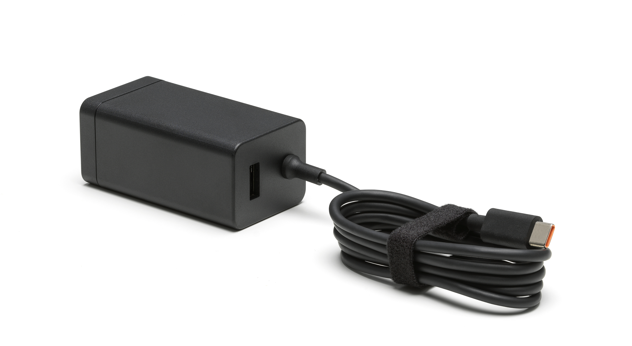 Schwarzes Netzteil mit USB-Anschluss und einem schwarzen Kabel, das mit einem Klettverschluss umwickelt ist.