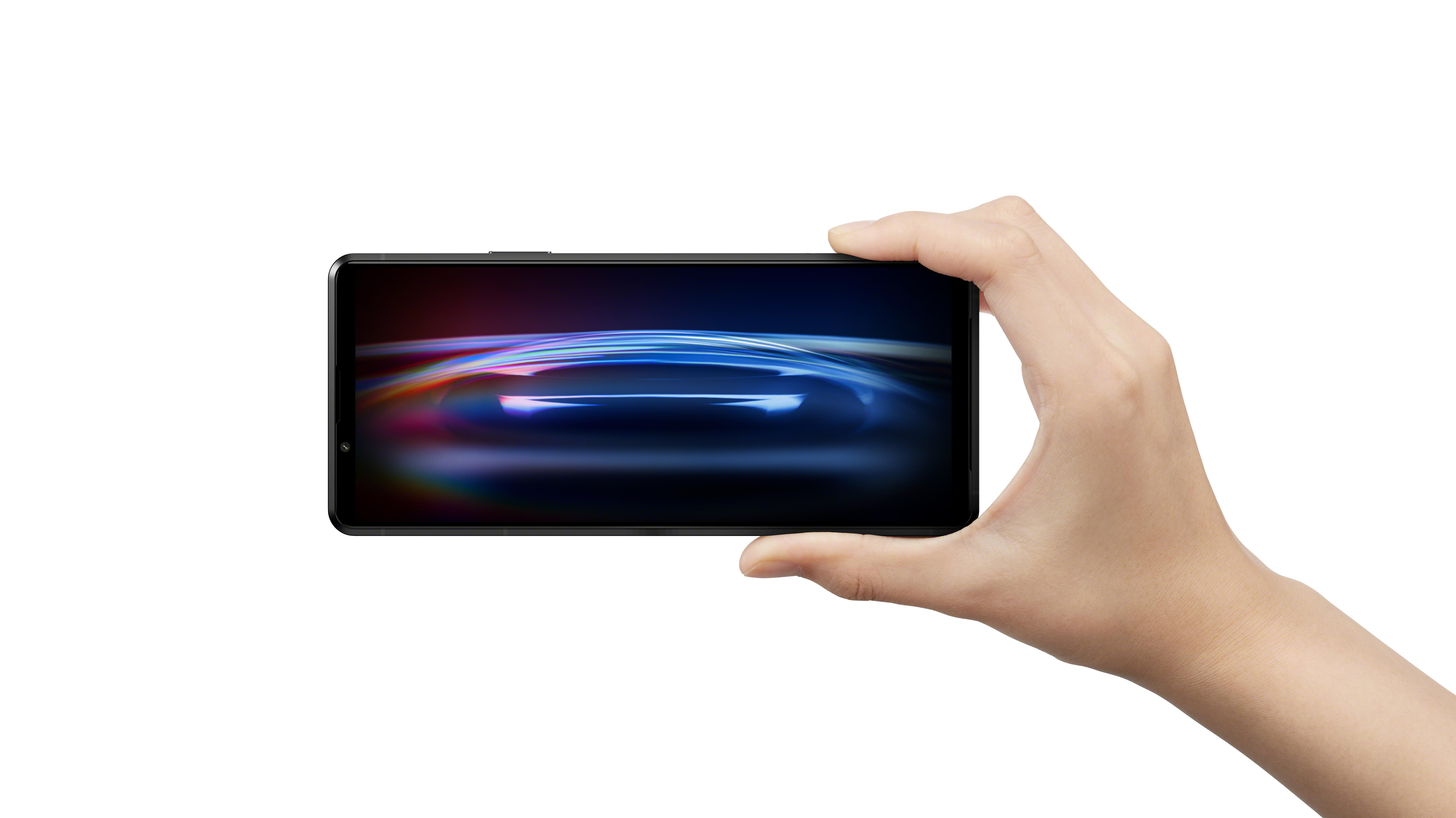 Eine Hand, die ein Telefon hält, das eine farbenfrohe, abstrakte Grafik anzeigt.