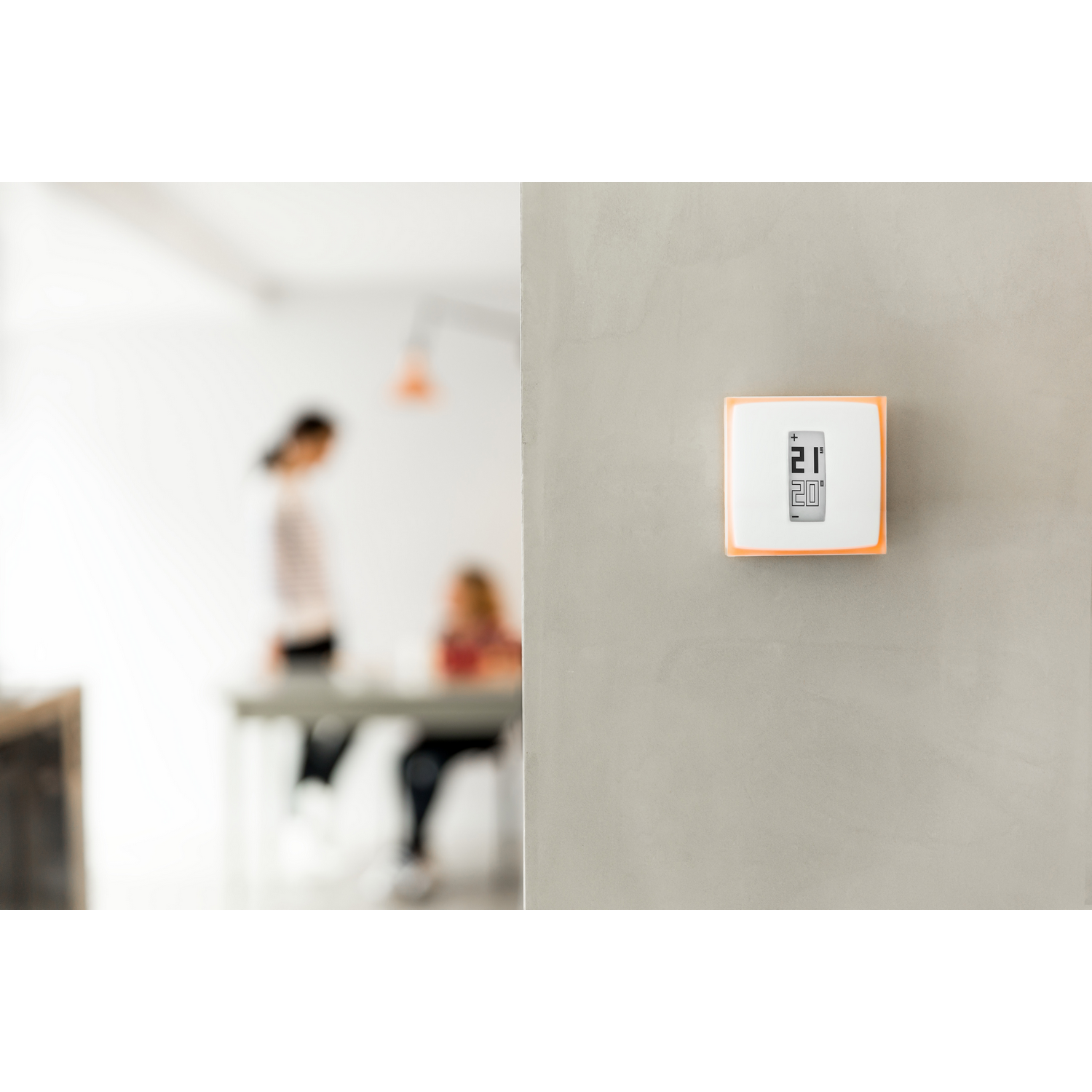 Termostato de pared con pantalla digital, ajustado a 21 grados.