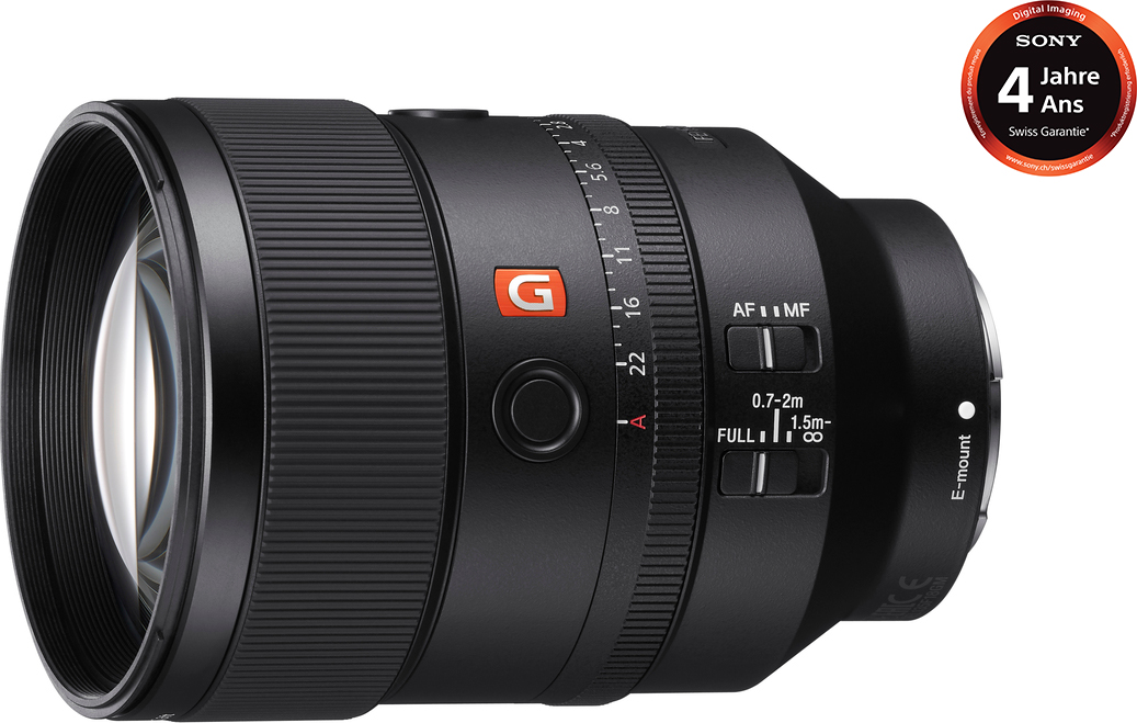 Obiettivo per fotocamera Sony nero, con ghiere di messa a fuoco e apertura. Logo arancione ed etichetta di garanzia.