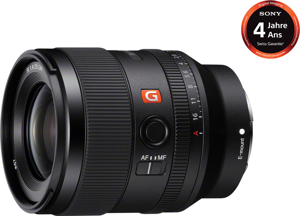 Un obiettivo nero con logo 'G' rosso. Ha indicatori di messa a fuoco e apertura. Logo Sony visibile.