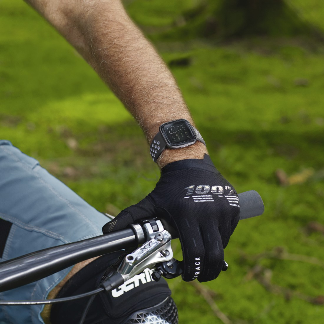 Person trägt Smartwatch auf dem Fahrrad, mit Handschuh.