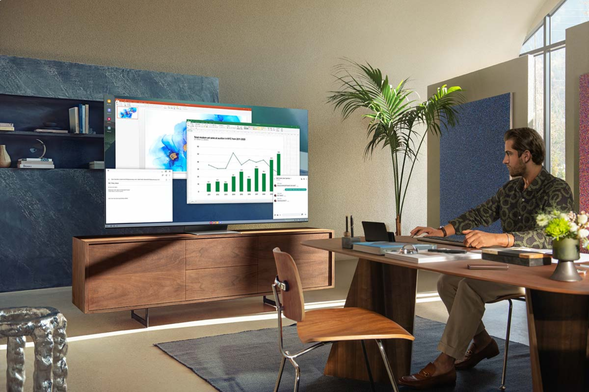 Un hombre sentado en un escritorio mirando una pantalla que muestra software.