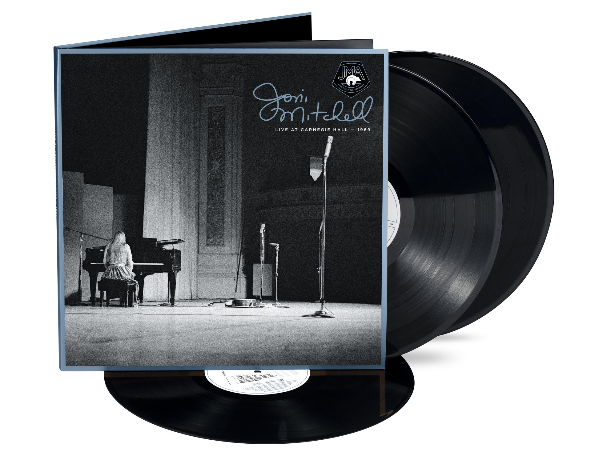 A Joni Mitchell Live at Carnegie Hall - 1969 album borítója. Mitchell zongorázik a színpadon, két fekete bakelitlemez látható.