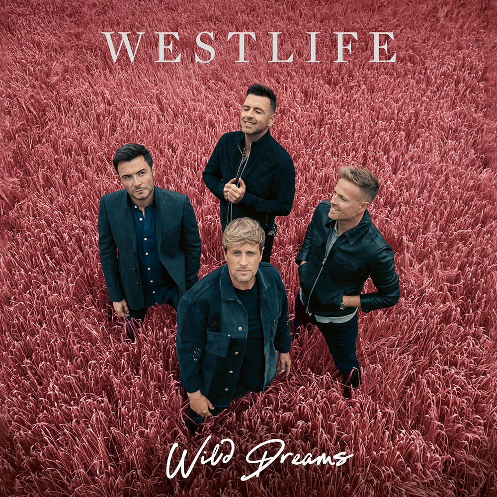 Vier Männer in einem Weizenfeld, Albumcover mit Text 'Westlife Wild Dreams'.