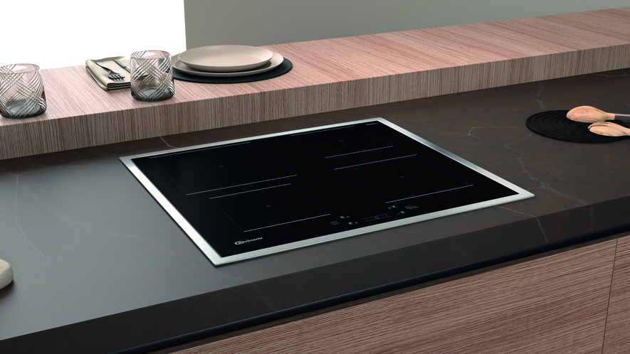 Ein Induktionskochfeld auf einer Holzoberfläche mit ein paar Gegenständen an der Seite.