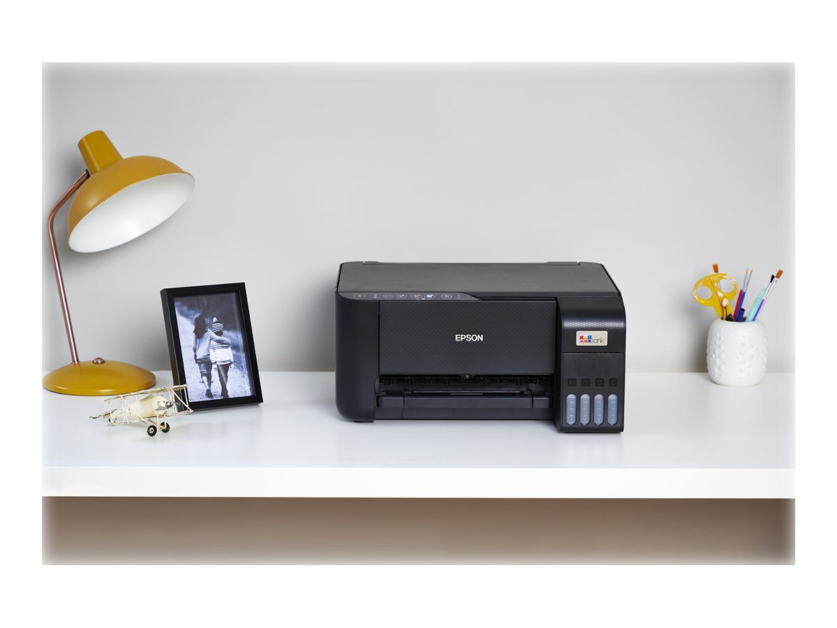 Epson-Drucker auf einem weißen Schreibtisch mit Lampe, Foto und Schreibwaren.