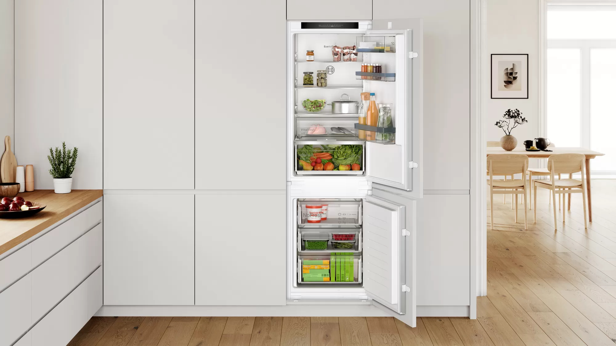 Weißer Einbaukühlschrank mit geöffneten Türen. Inhalt sichtbar: Lebensmittel, Getränke.