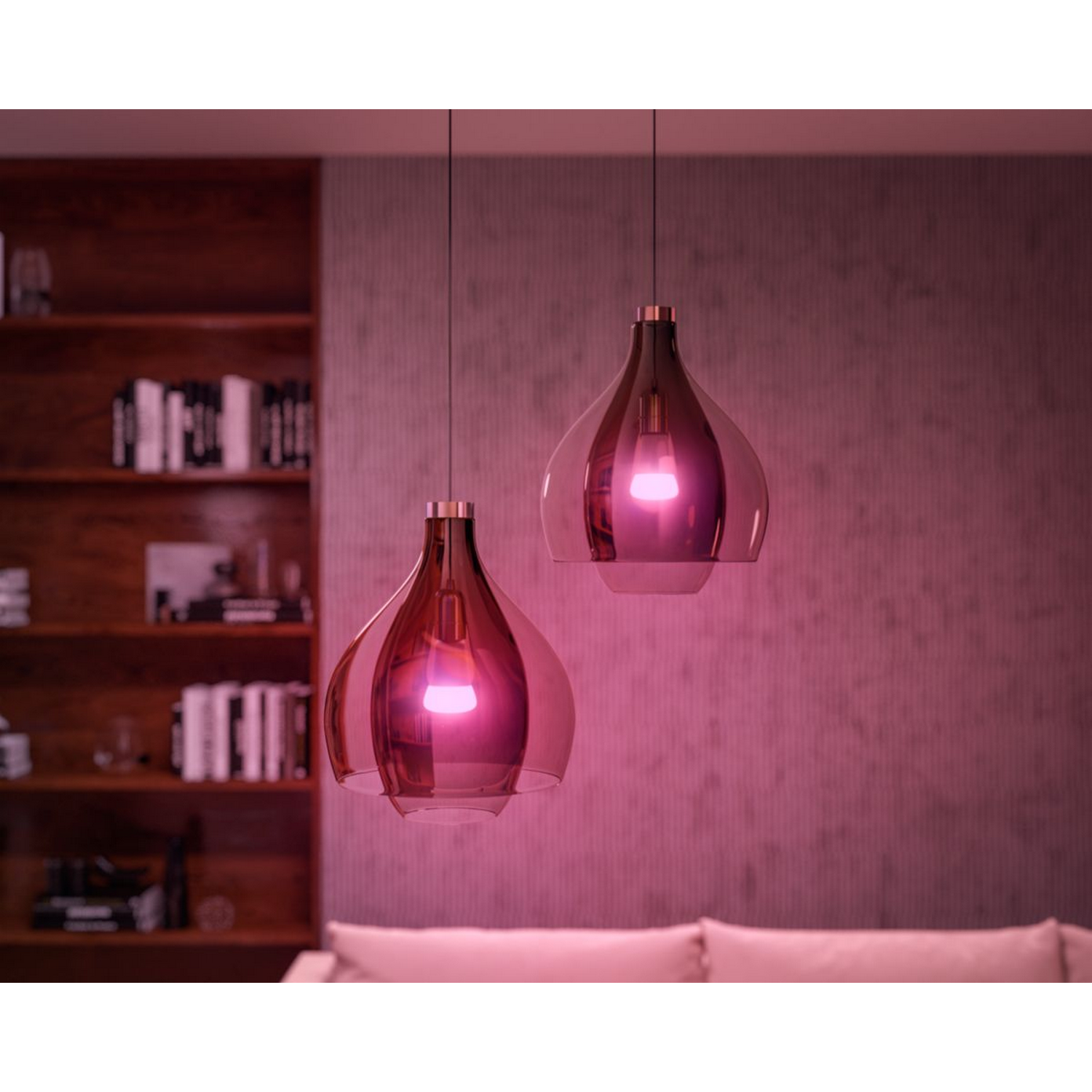 Dos lámparas colgantes con una cúpula de cristal. Las luces son rosas e iluminan la habitación.
