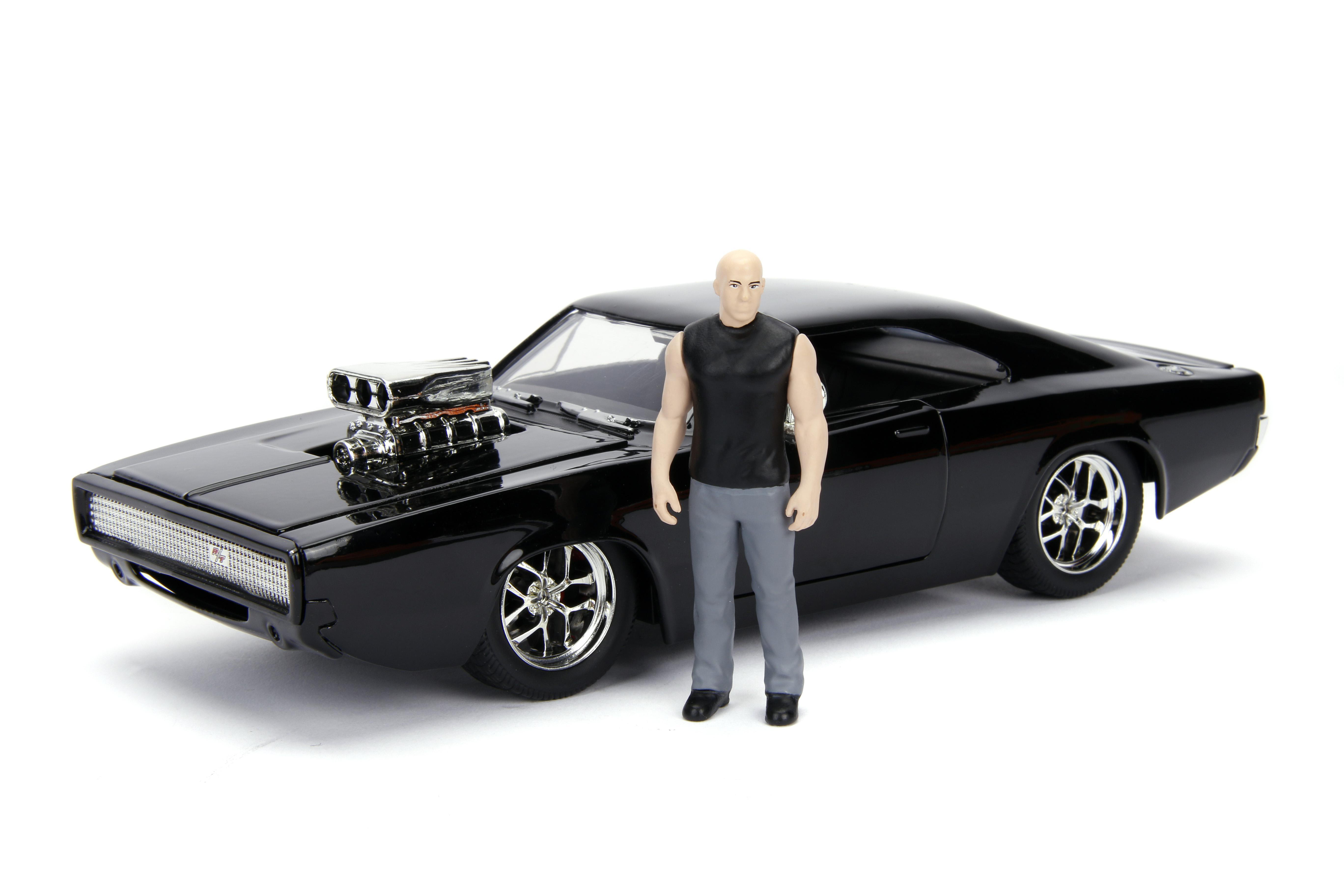 Eine Spielfigur eines Mannes neben einem schwarzen Auto mit großem Motor.