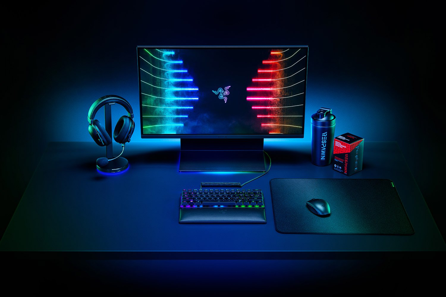 Une configuration de jeu avec un moniteur, un casque, un clavier et une souris sur un bureau noir.