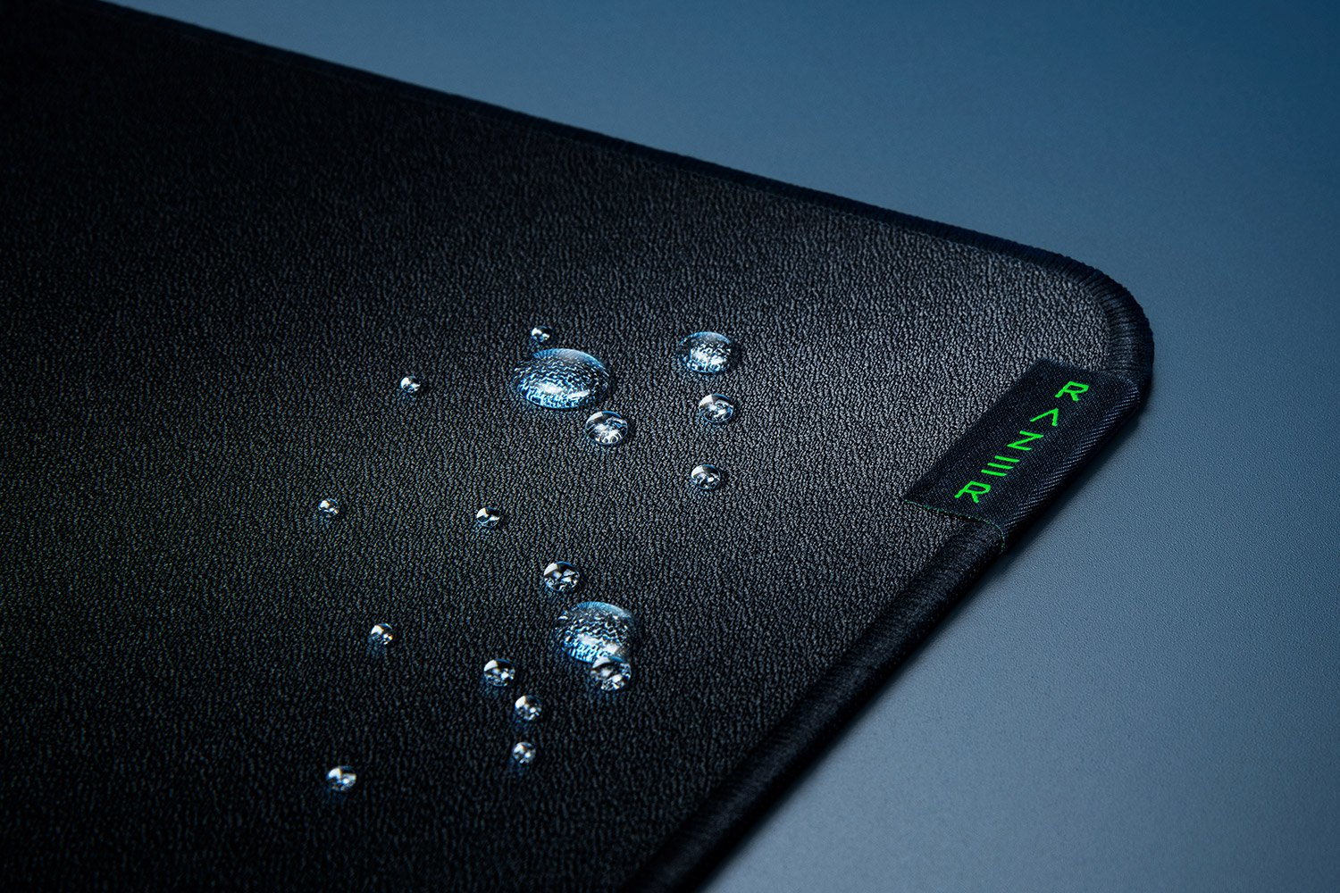 Un tapis de souris noir avec des gouttes d'eau, avec le logo Razer.