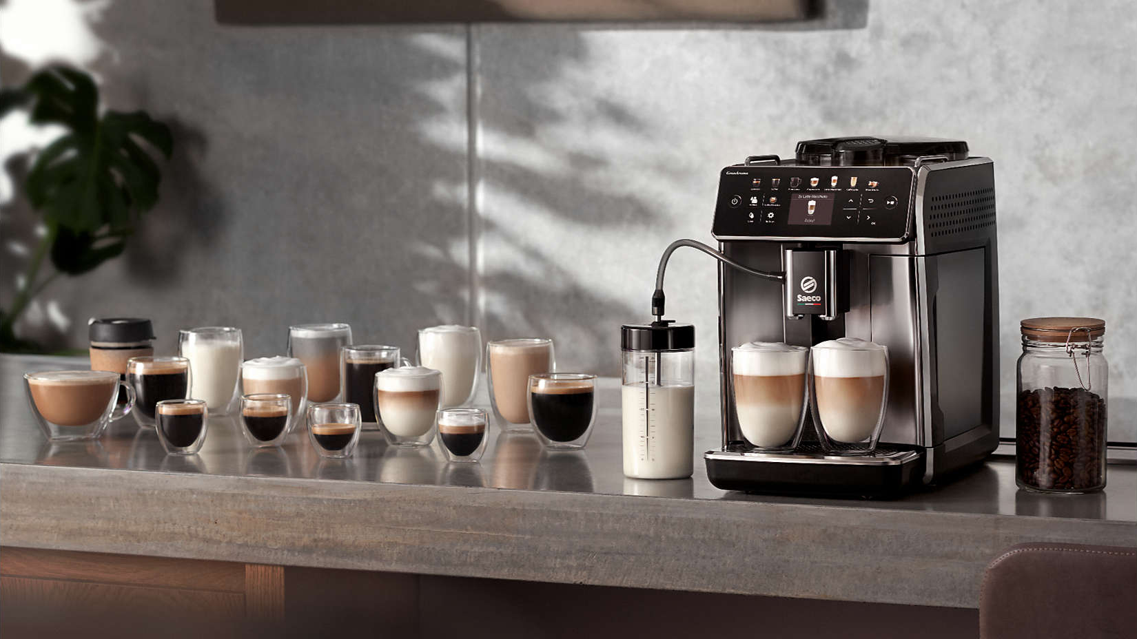 Macchina da caffè con bicchieri latte. Una varietà di bevande al caffè sono esposte su un bancone.