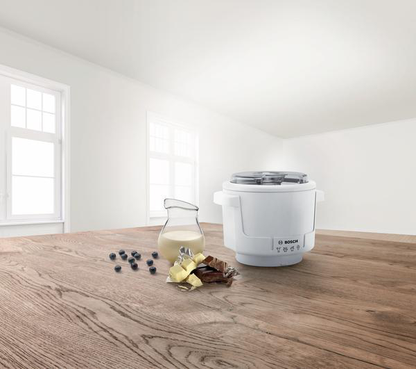 Weißer Eisbereiter auf einem Holztisch mit Zutaten.