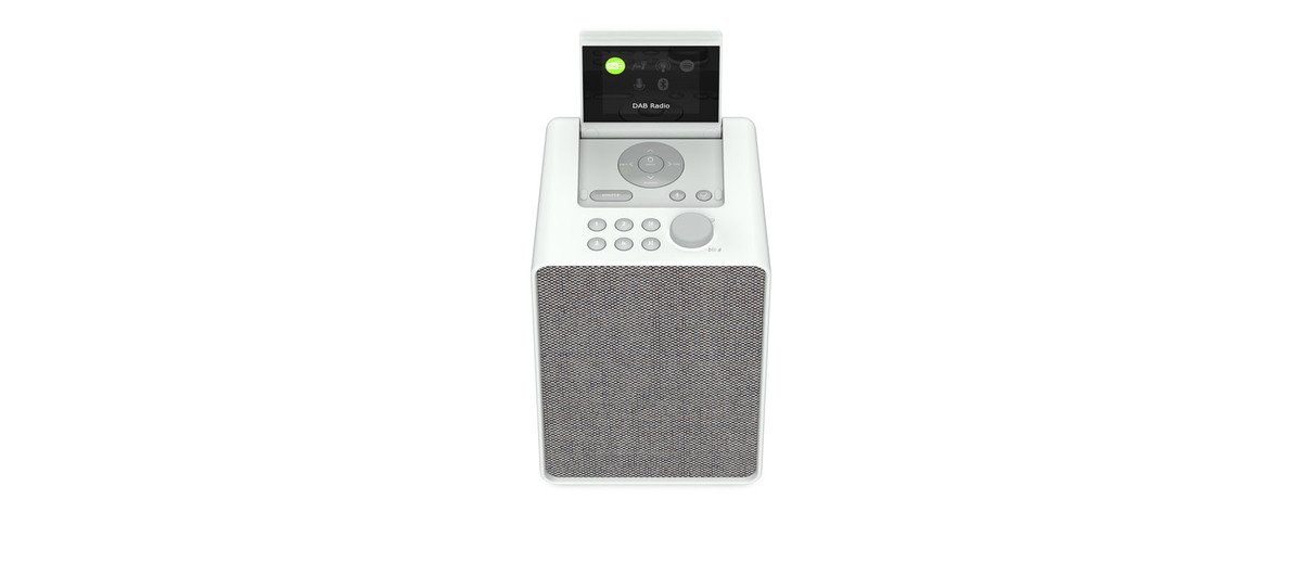 Weißes Radio mit 'DAB Radio' auf dem Bildschirm. Steht auf weißer Oberfläche.