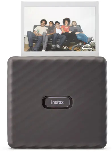 A black Instax printer with a printed photo showing people on a couch.