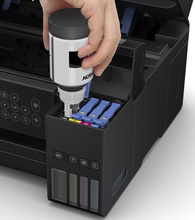 Een persoon die inkt in een Epson-printer vult, met zwarte, gele, magenta en cyaan containers.