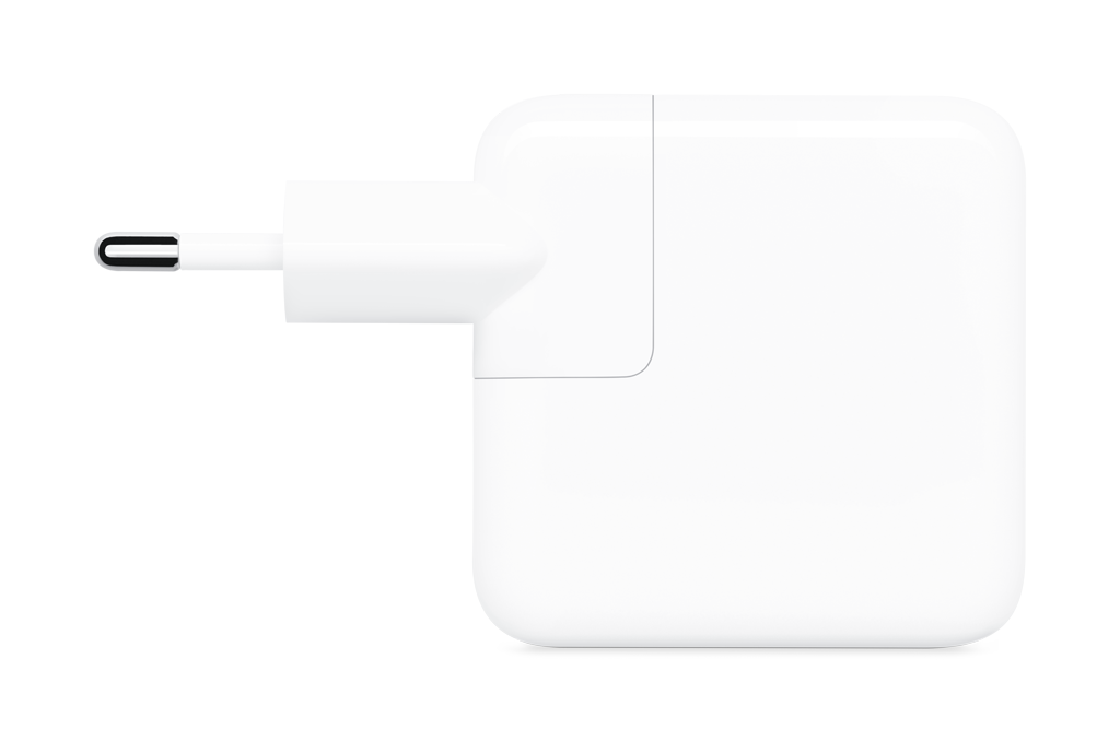 Un adaptador de corriente blanco de Apple con clavija, sobre fondo negro.